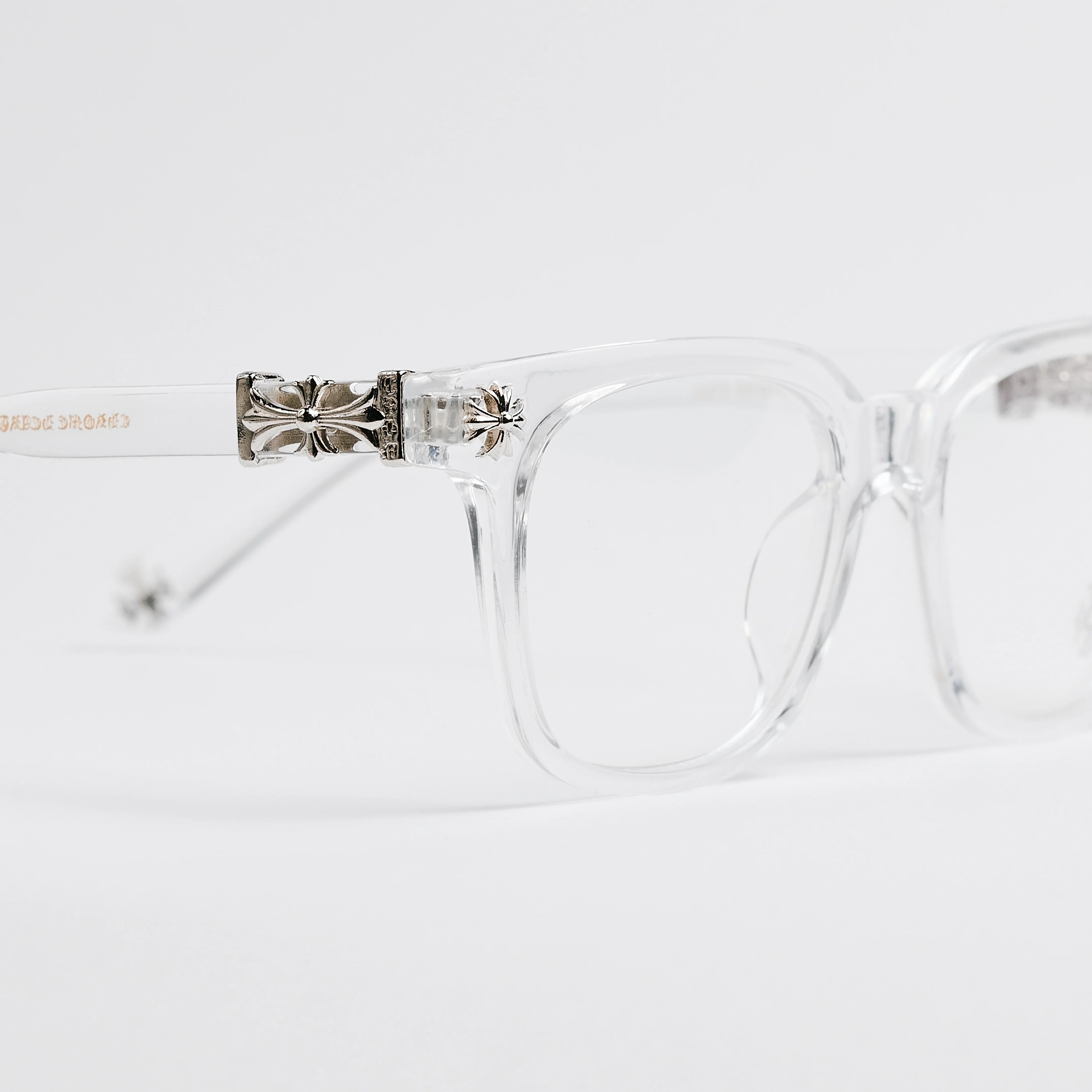 Clear eyeglasses with decorative metal bridge on a white background